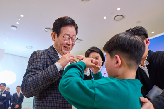 이재명 대통령이 지난해 12월 24일 서울 서대문구 신촌세브란스 연세암병원 중입자치료센터에서 열린 희귀질환 환우·가족 간담회를 마친 후 어린이에게 손하트를 그려보이고 있다. 사진 대통령실