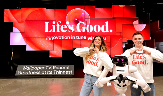 LG전자가 미국 라스베이거스에서 열리는 가전·정보기술(IT) 박람회 ‘CES 2026’ 전시관 입구에 초슬림·초밀착 무선 월페이퍼 TV ‘LG 올레드 에보 AI W6’ 38대를 천장에 매단 초대형 오브제로 관람객들을 맞이한다. 홈 로봇 'LG 클로이드'와 모델들이 초대형 오브제 앞에서 다양한 포즈를 취하고 있다. 사진 LG전자