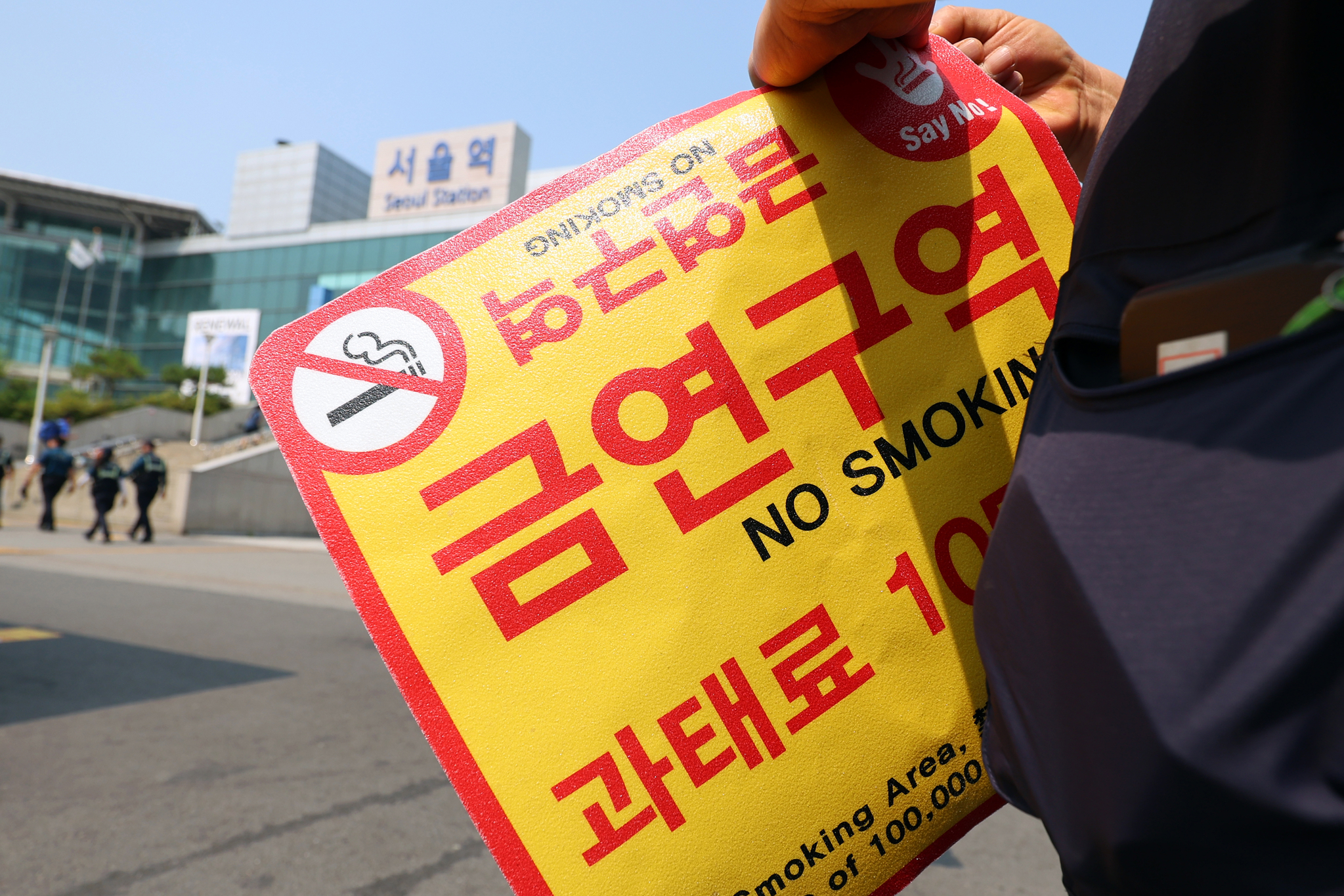서울역광장에서 구청 관계자들이 '금연구역' 안내 스티커를 붙이고 있다. 뉴스1