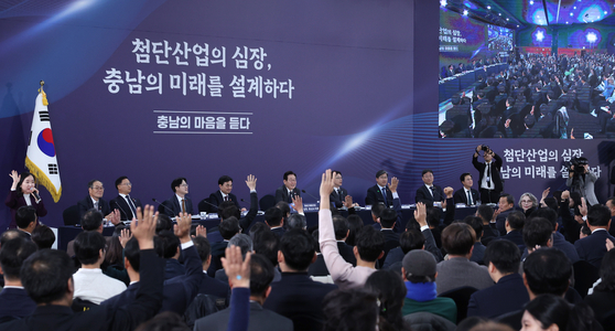 이재명 대통령이 지난해 12월 5일 충남 천안시 한국기술교육대학교 담헌홀에서 열린 ‘첨단산업의 심장, 충남의 미래를 설계하다’ 타운홀 미팅에서 충남·대전 통합 관련 참석자들의 의견을 거수로 확인하고 있다. 대통령실 사진기자단