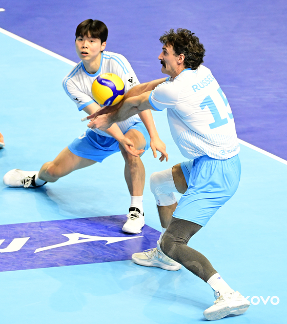 대한항공 외국인 선수 러셀(오른쪽)이 팀 동료와 엇갈리며 상대 서브에 불안한 표정으로 손을 갖다대고 있다. [사진 KOVO]