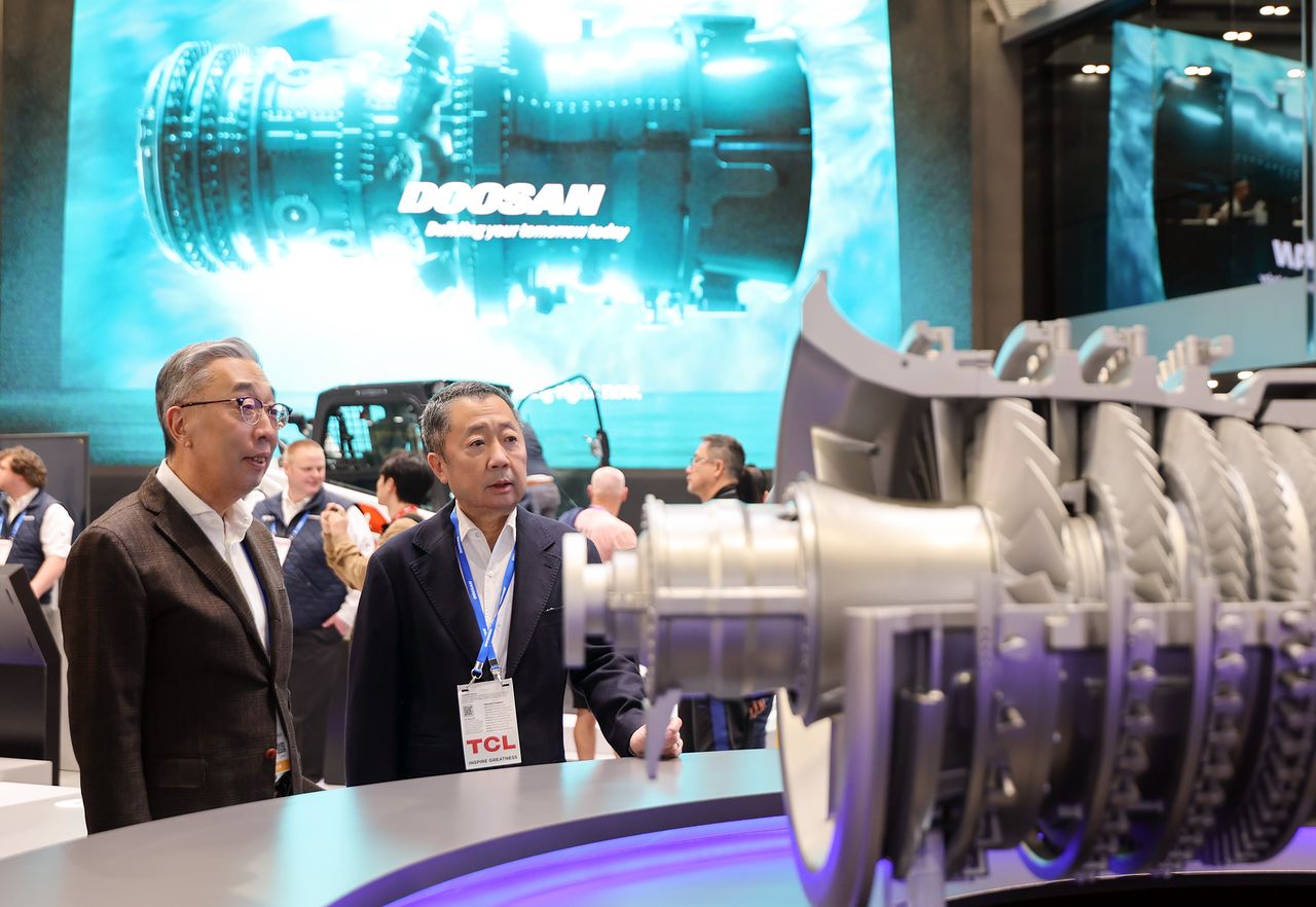 박정원 두산그룹 회장(오른쪽)과 박지원 그룹부회장이 7일(현지시간) 미국 라스베이거스에서 열린 세계 최대 가전·정보기술(IT) 전시회 ‘소비자 가전쇼(CES 2026)’ 현장에서 두산 부스에 전시된 가스터빈 모형을 살펴보고 있다. 사진 두산
