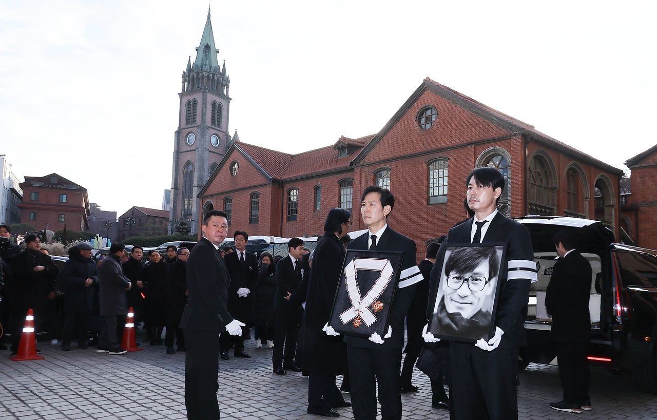 고인에게 추서된 금관문화훈장을 든 배우 이정재(왼쪽), 영정사진을 든 배우 정우성. 임현동 기자