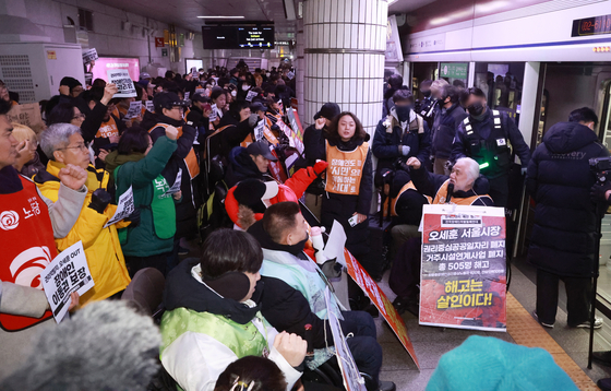 전국장애인차별철페연대(전장연) 회원들이 2일 서울 지하철 1호선 시청역에서 제68차 '지하철 탑시다' 시위를 벌이고 있다. 연합뉴스