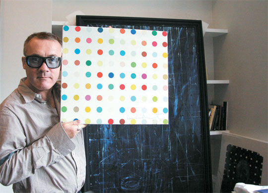 2008년 6월 런던 사무실에서 인터뷰 당시의 데미안 허스트. 사진을 찍자고 하자 선반 위에 놓인 작은 도트 페인팅을 집어들고 익살맞은 포즈를 취했다. “경매 사이트 이베이에서 이 가짜 그림이 돌고 있는 걸 발견하고는 얼른 사서 내 서명을 했다”고 말했다. 런던=권근영 기자