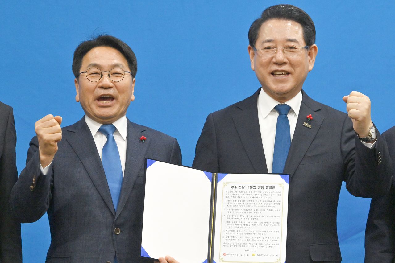 강기정(왼쪽) 광주시장과 김영록 전남도지사가 9일 오후 광주 서구 김대중컨벤션센터에서 열린 광주.전남 행정통합 시도민 보고회에 참석해 공동발표문을 들고 화이팅을 외치고 있다. 뉴시스