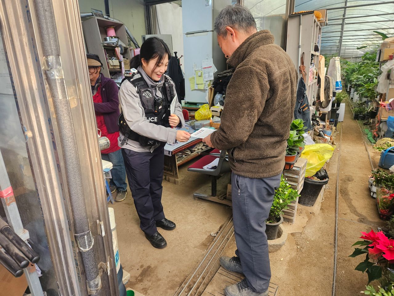 부산경찰이 해운대구 반여동 화훼단지를 방문해 공공기관 사칭 사기 방지를 위해 제작한 소책자를 나눠주고 있다. 사진 부산경찰청