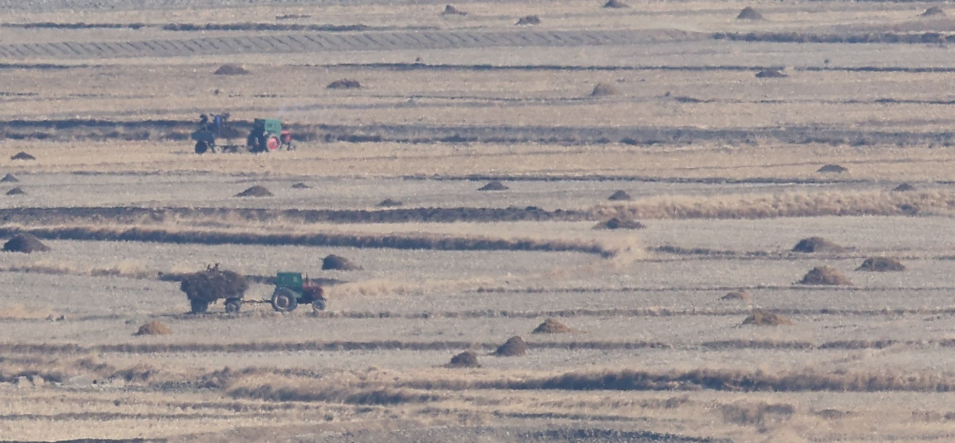 11일 인천 강화군 강화평화전망대에서 바라본 북한 황해북도 개풍군 들녘에서 주민들이 트랙터를 이용 거름을 옮기고 있다. 북한 김여정 노동당 부부장은 이날 조선중앙통신 담화를 통해 한국발 무인기가 북한 영공을 침범했다며 책임을 경고했다. 연합뉴스 