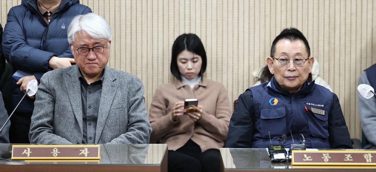 김정환 서울시버스운송사업조합 이사장(왼쪽)과 박점곤 서울시 버스노동조합 위원장이 12일 오후 서울 영등포구 서울지방노동위원회에서 열린 특별조정위원회 사후 조정회의에 나란히 앉아 있다. [뉴스1]