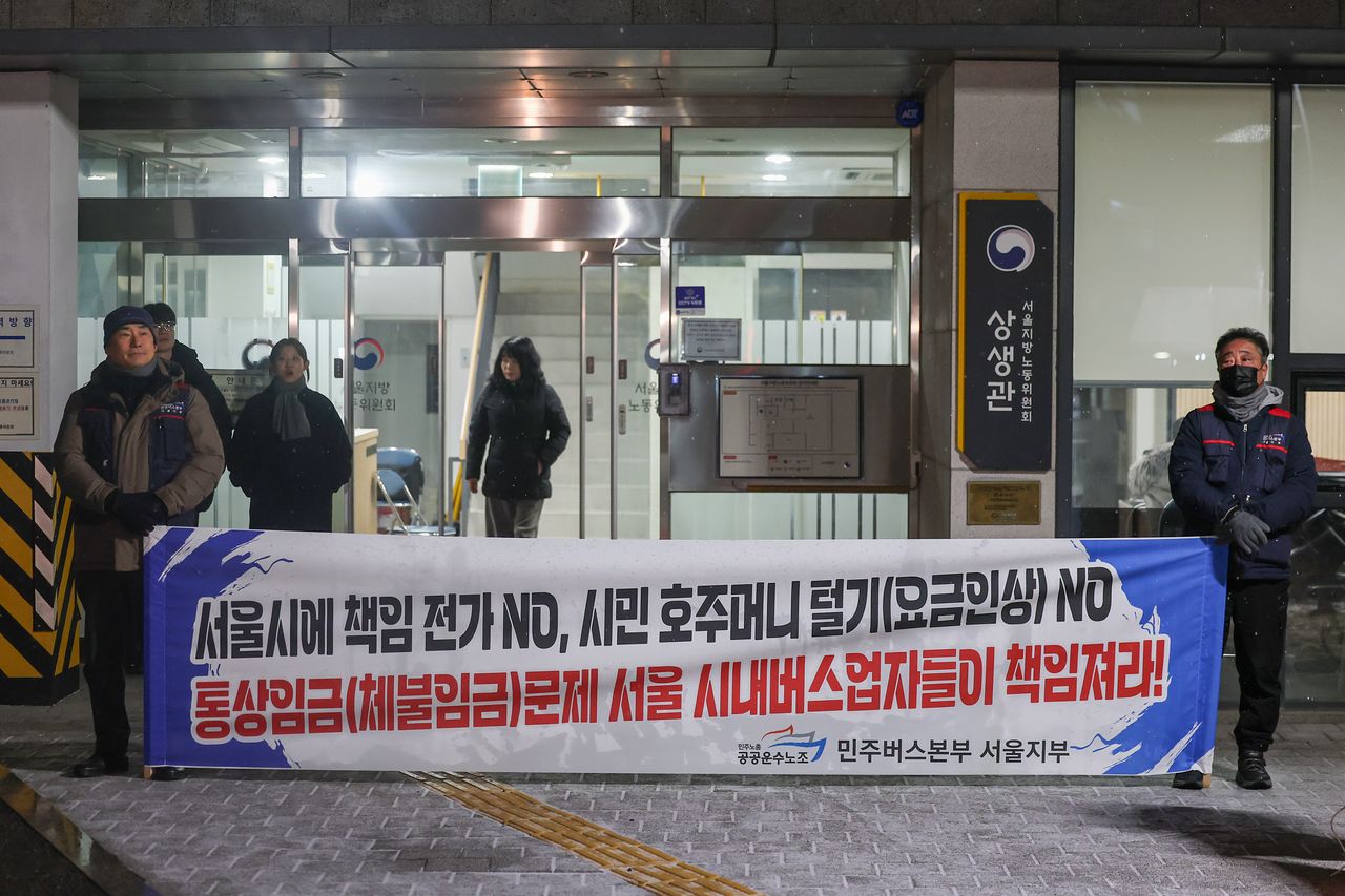 서울 시내버스 노사 특별조정위원회 사후 조정회의가 열린 12일 서울 영등포구 서울지방노동위원회에서 전국민주노동조합총연맹(민주노총) 민주버스본부 서울지부 조합원들이 사측을 규탄하는 현수막을 펼치고 있다. [연합뉴스]