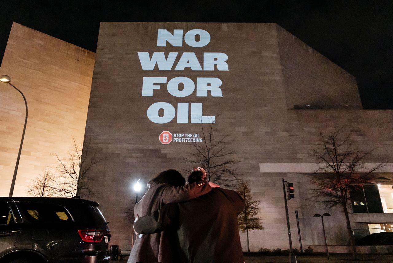 지난 8일 반전 활동가들이 미국 워싱턴의 한 건물 벽에 베네수엘라 석유 확보를 노린 미국의 군사작전에 반대하는 구호를 프로젝션으로 비추고 있다. [AP=연합뉴스]