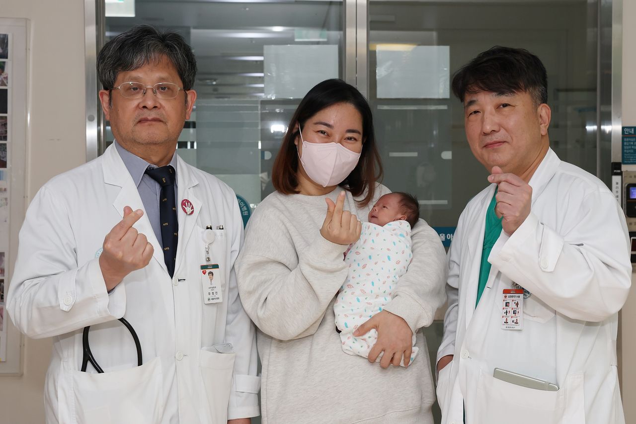 왼쪽부터 유정진 서울아산병원 선천성심장병센터장, 홍이준군 어머니와 홍군 수술을 집도한 윤태진 서울아산병원 소아심장외과 교수가 홍군의 퇴원을 앞두고 기념 촬영을 하고 있는 모습. 사진 서울아산병원