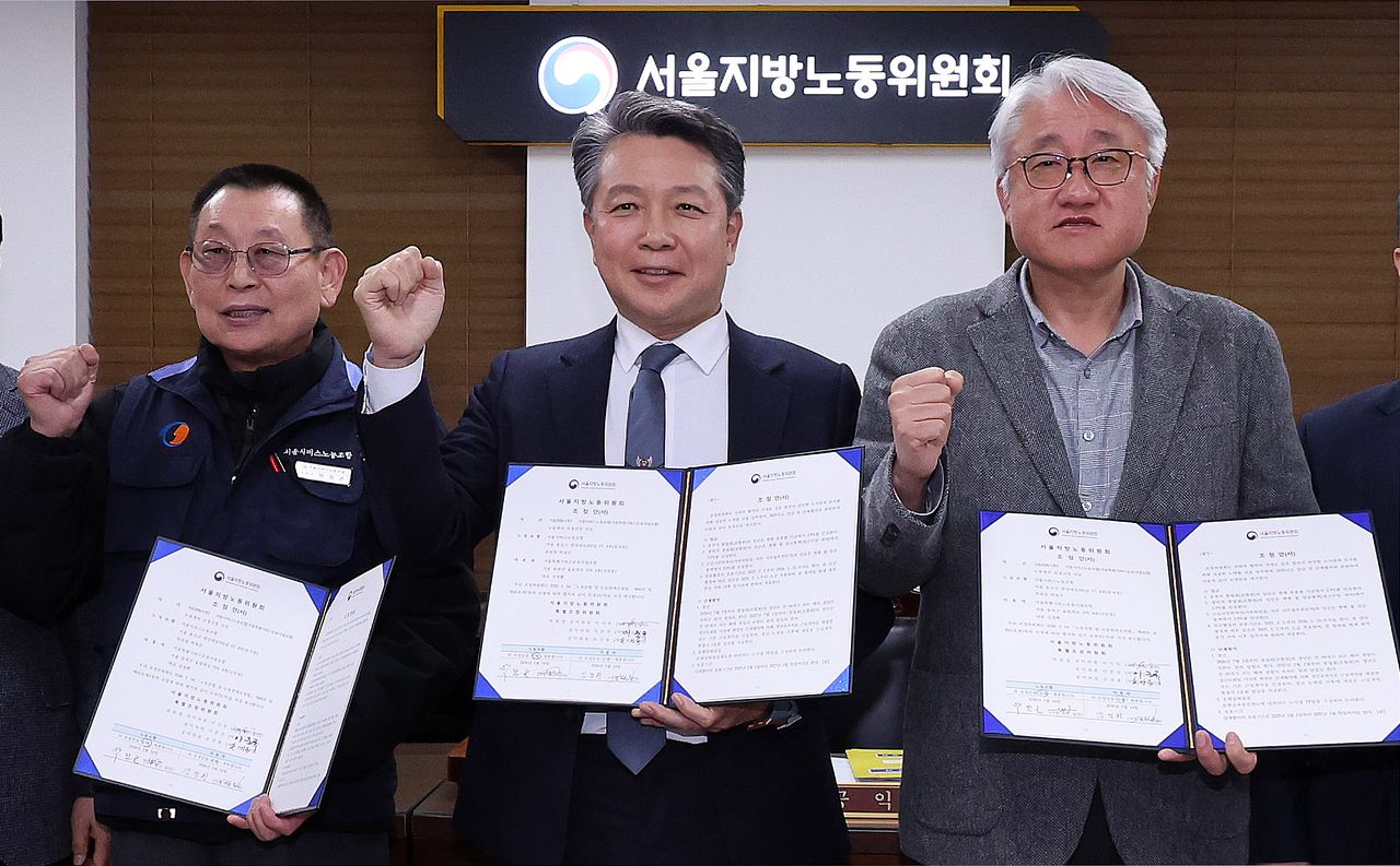 서울 영등포구 서울지방노동위원회에서 열린 특별조정위원회 2차 사후 조정회의에서 서울 시내버스 노사가 임금협상에 극적으로 합의한 뒤 박점곤 서울시버스노동조합 위원장과 김정환 서울시버스사업조합 이사장을 비롯한 참석자들이 기념 촬영을 하고 있다. [뉴스1]