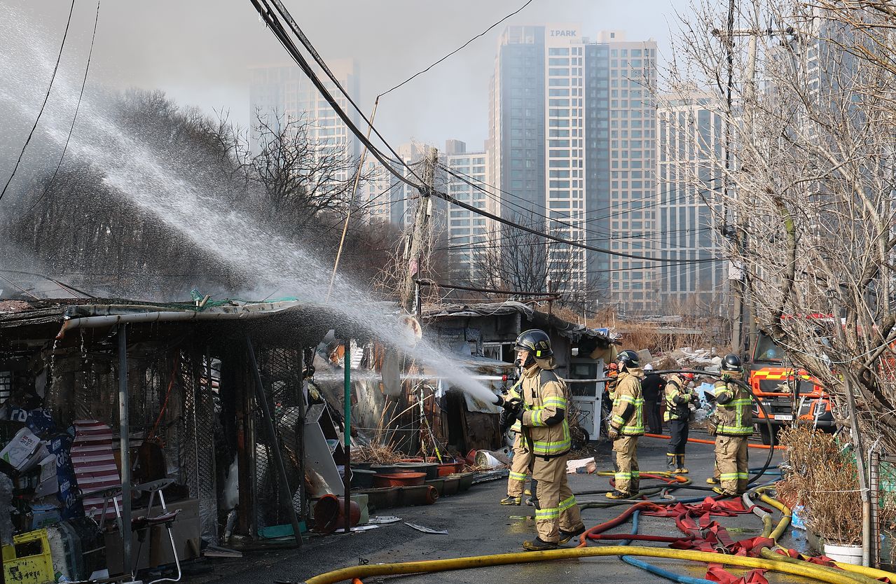 16일 서울 강남구 개포동 구룡마을에서 소방관들이 잔불을 진압하고 있다. [연합뉴스]