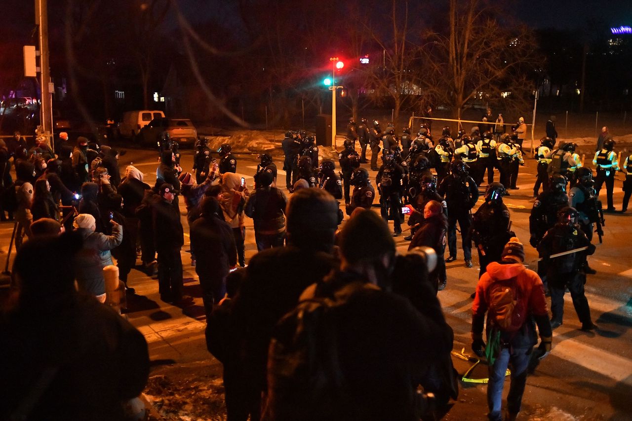 14일(현지시간) 미국 미네소타주 미니애폴리스에서 이민세관단속국(ICE) 요원이 베네수엘라 남성을 총격한 사건 이후 연방 법 집행 요원과 경찰관들이 시위대와 대치하고 있다. AFP=연합뉴스