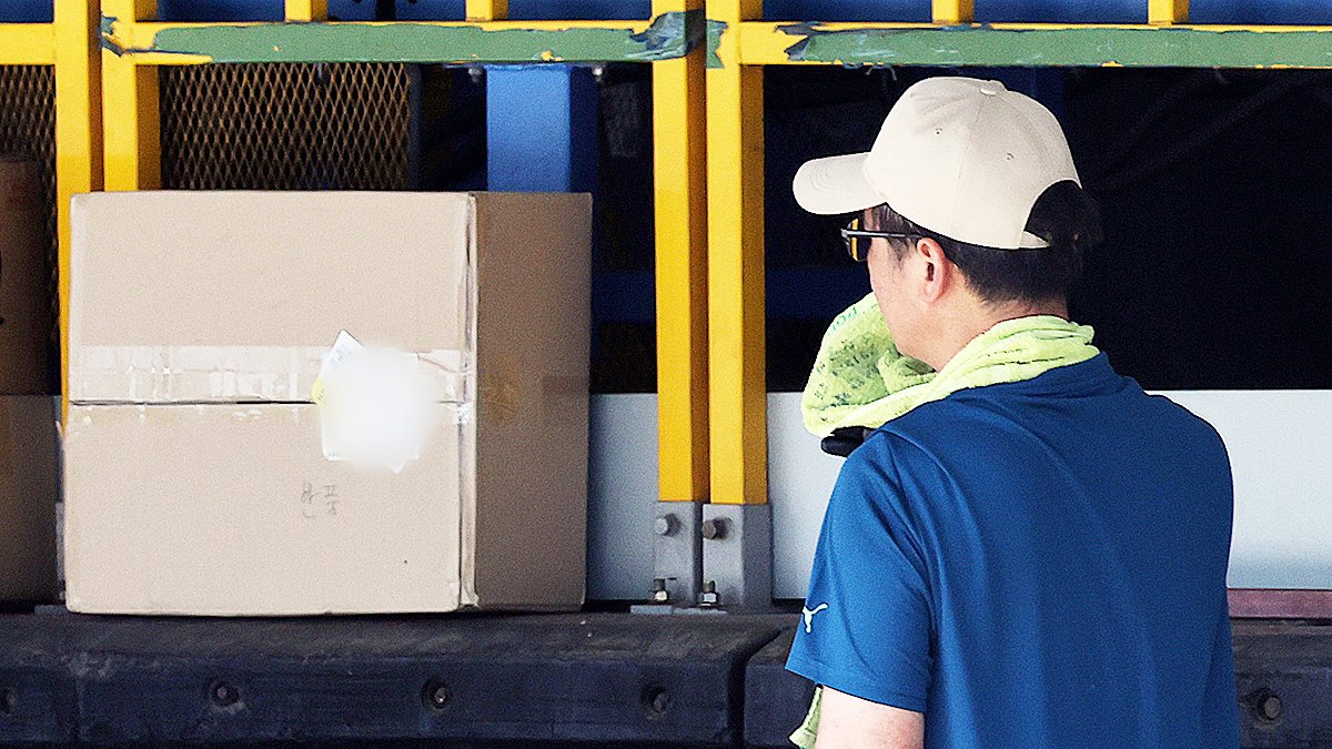 연일 폭염이 이어지던 지난해 7월 초 서울 시내 한 택배물류센터에서 노동자가 택배 분류 작업 중 땀을 닦고 있다.  뉴스1