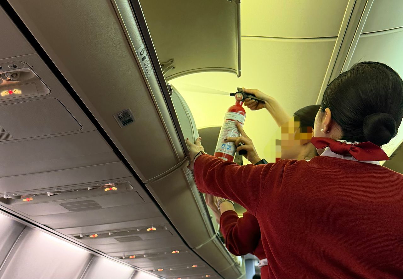 17일 객실에서 피어오른 연기를 끄는 이스타항공 승무원들. 연합뉴스