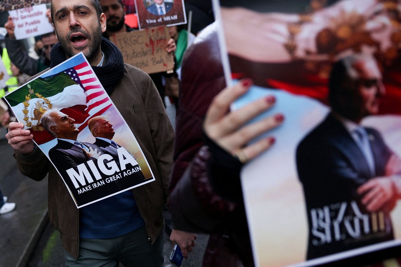 시위자가 "이란을 다시 위대하게(Make Iran Great Again)"라고 적힌 플래카드를 들고 있다. 현지시간 17일 스페인 마드리드 이란 전국 시위 지지 집회에서 도널드 트럼프 미국 대통령과 이란 마지막 샤의 망명 중인 아들이자 이란 반체제 인사인 레자 팔라비(Reza Pahlavi)를 묘사한 이미지가 함께 보인다. 로이터=연합뉴스