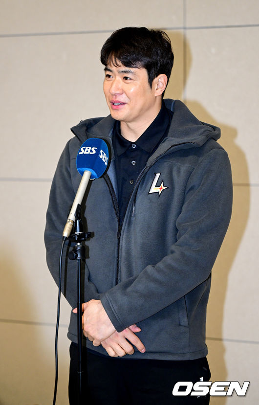 두 손을 앞으로 모은채 출국 인터뷰를 갖는 김재환.  