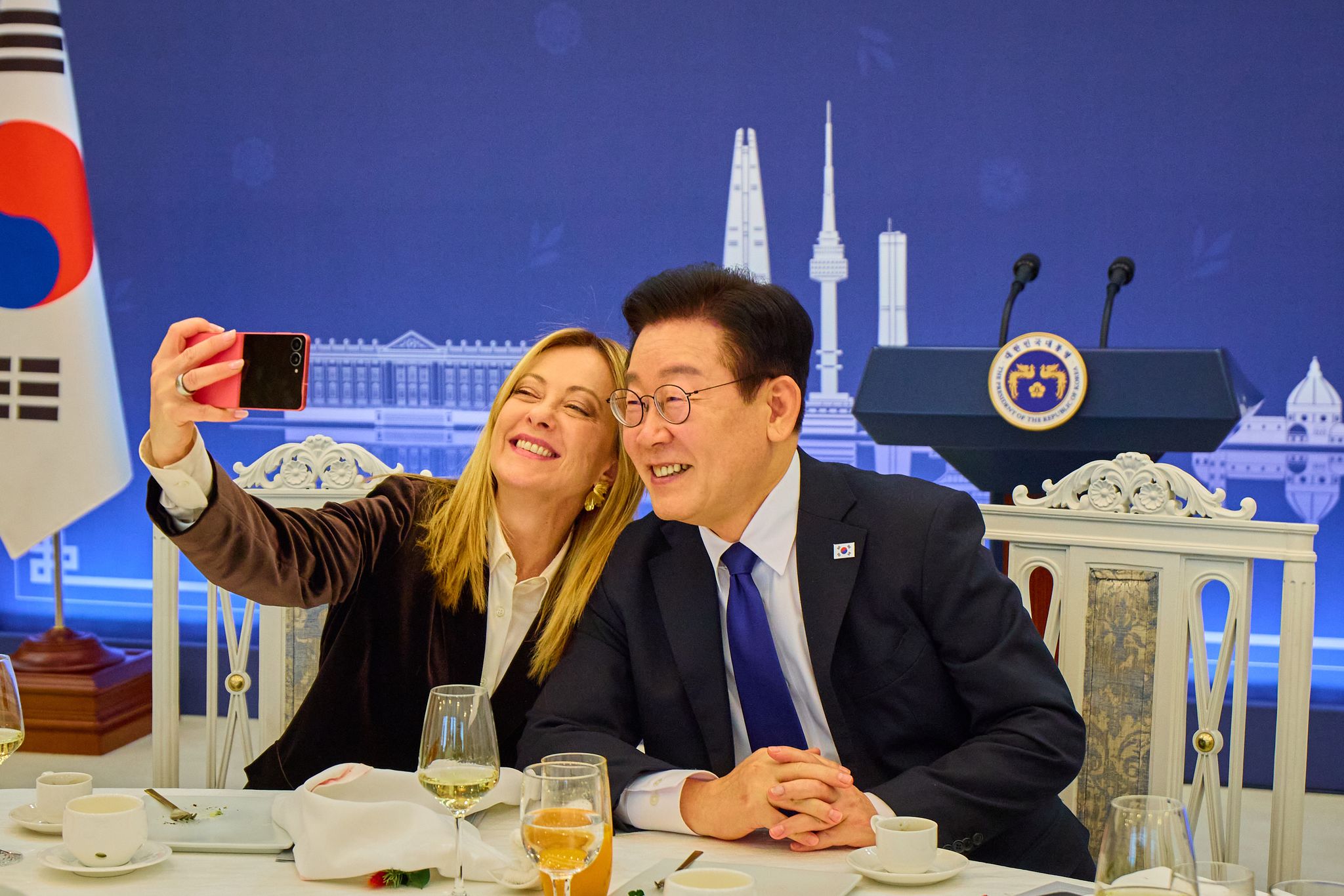 이재명 대통령과 조르자 멜로니 이탈리아 총리가 19일 청와대 본관에서 열린 공식오찬장에서 함께 셀카를 찍고 있다. 청와대는 오찬 중 대통령이 총리에게 선물한 삼성 갤럭시 Z플립7 핑크로 함께 셀카 찍었다고 밝혔다. 사진 청와대