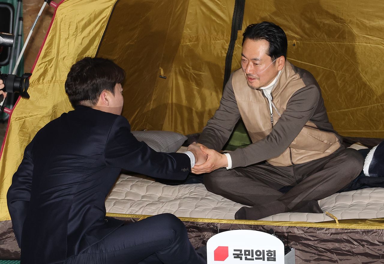 통일교·공천헌금 '쌍특검' 수용을 요구하며 단식 7일 차를 맞은 국민의힘 장동혁 대표가 21일 서울 여의도 국회 로텐더홀 단식 농성장을 찾은 개혁신당 이준석 대표와 악수하고 있다. 연합뉴스