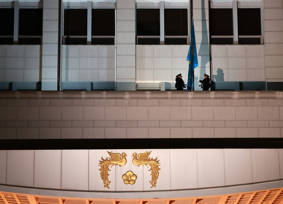 지난해 12월 29일 자정 서울 용산 대통령실 청사에서 대통령의 상징인 봉황기가 내려지고 있다. 이 건물은 국방부가 2022년 대통령실에 내줬다. 대통령실이 청와대로 되돌아 갔지만, 국방부는 원래 건물로 가지 못한 상태다. [청와대사진기자단]