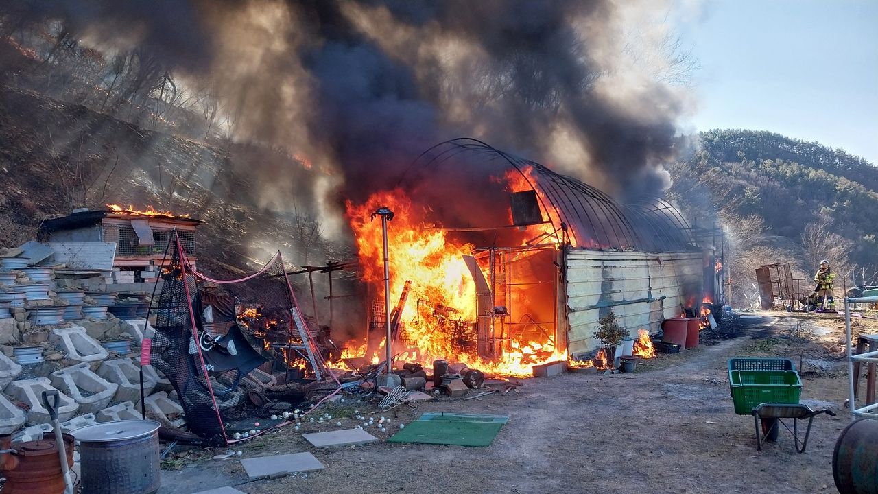 22일 오후 경남 진주시 집현면에서 창고로 쓰는 한 농막에서 난 불이 인근 야산으로 번져 산림당국이 진화 중이다. 사진 경남소방본부