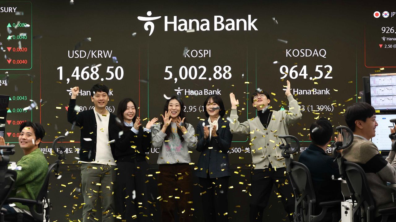 코스피가 사상 처음으로 장중 5000포인트를 돌파한 22일 하나은행 딜러들이 축하행사를 하고 있다. [뉴스1]