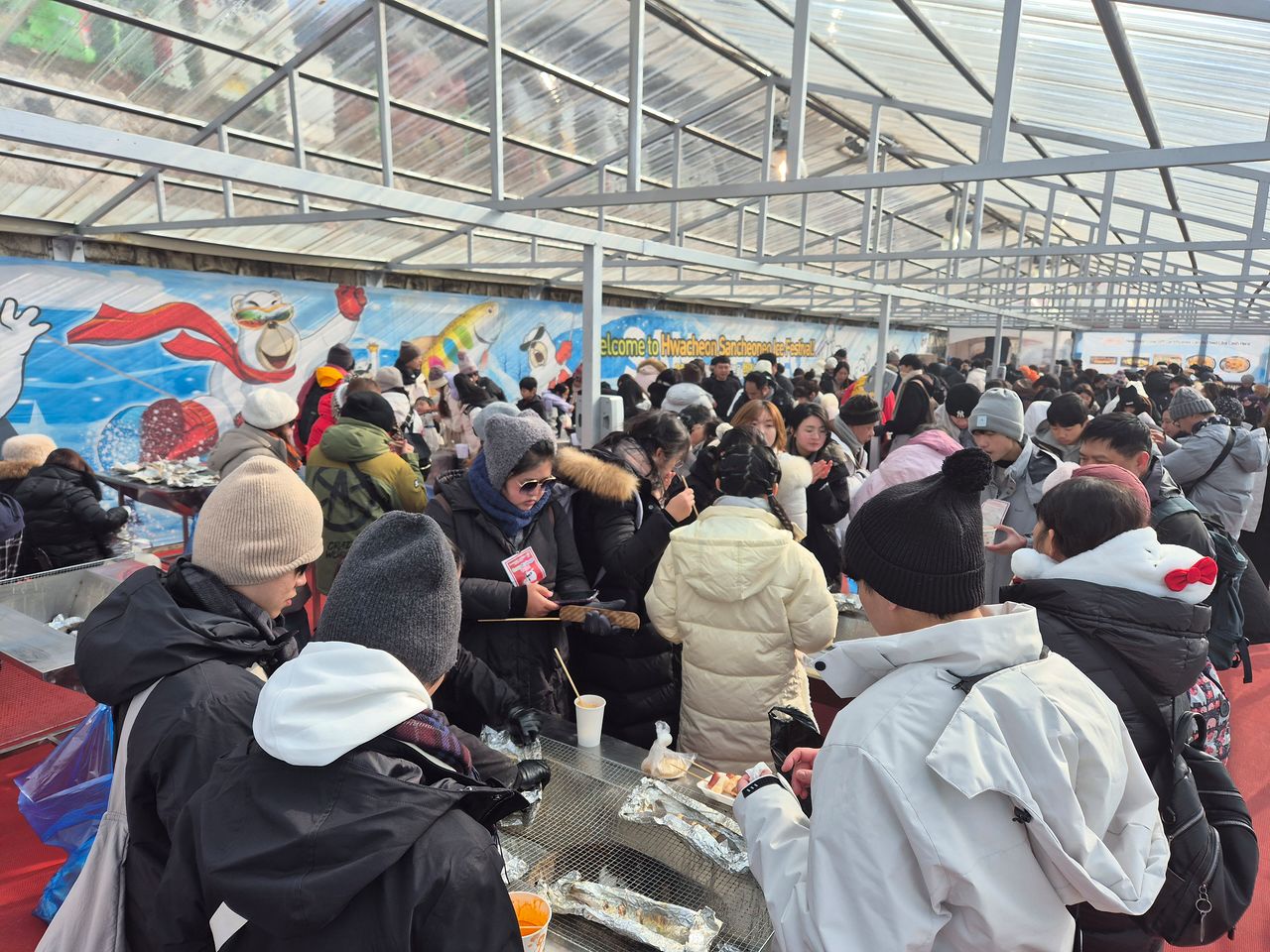 23일 오후 강원 화천군 화천천에서 열린 화천산천어축제장을 찾은 관광객들이 구이터에서 직접 잡은 산천어를 맛보는 모습. 박진호 기자