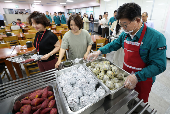 최충규 구청장이 비상식량인 주먹밥과 고구마를 배식하고 있다. 뉴스1