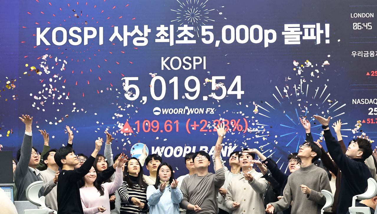 코스피 지수가 장중 사상 처음으로 5019.54를 기록한 22일 서울 중구 우리은행 본점 딜링룸에서 딜러들이 코스피 지수 5,000선 돌파를 축하하고 있다. 연합뉴스
