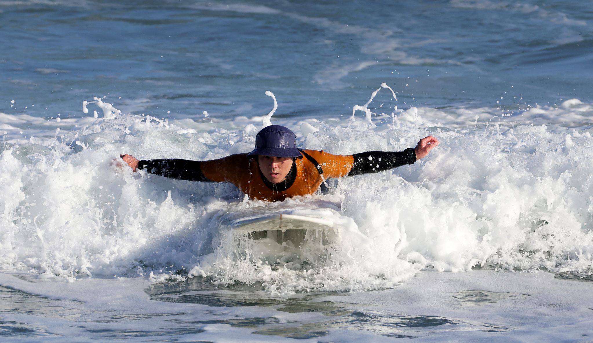 한 서퍼가 패들링으로 해안가로 향하고 있다.