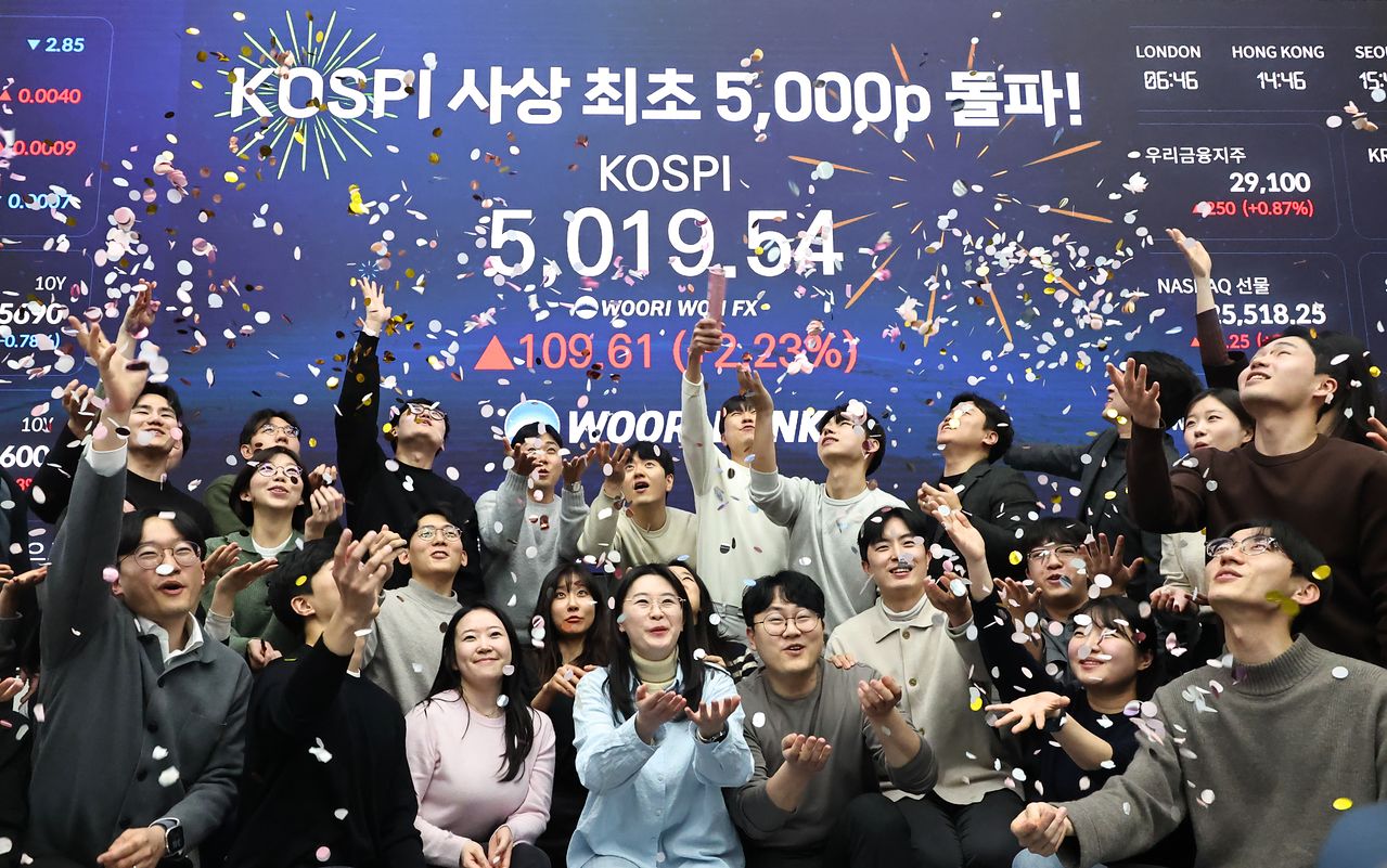 코스피 지수가 장중 사상 처음으로 5,019.54를 기록한 22일 서울 중구 우리은행 본점 딜링룸에서 딜러들이 코스피 지수 5,000선 돌파를 축하하고 있다. 연합뉴스