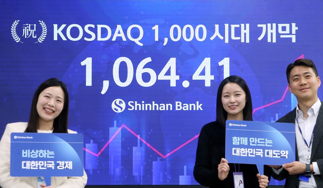 26일 ‘천스닥’ 시대 개막을 축하하는 문구가 띄워진 신한은행 딜링룸 전광판 앞에서 직원들이 기념 촬영을 하고 있다. 신한은행 제공