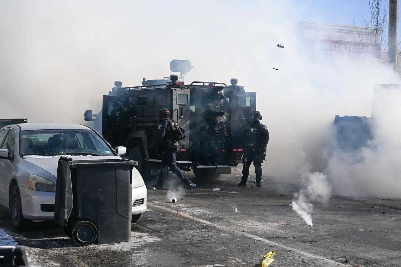 미네소타주 미니애폴리스에서 현지시간 24일, 연방 이민국 요원들이 한 남성을 사살한 현장 근처에서 경찰관들이 시위대를 향해 최루탄을 투척하고 있다.AFP=연합뉴스