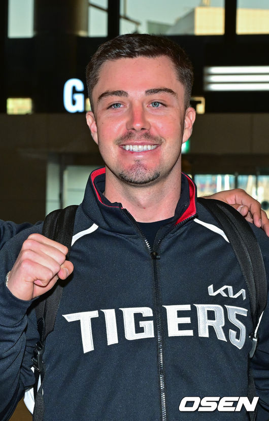 [OSEN=김포공항, 박준형 기자] 2026시즌 스프링캠프 나서는 KIA 코칭스태프와 외국인 선수들이 22일 김포국제공항을 통해 일본 아마미오시마로 출국했다. 지난해 미국 캘리포니아 어바인에서 훈련했던KIA는 일본 가고시마현의 외딴섬인 아마미오시마로 1차 훈련지로 정했다. 심재학 KIA 단장은 “미국에서 훈련해서 원하던 결과를 얻지 못했다”면서 “시차 등을 고려해도 일본이 낫다고 평가했다. 현지 실사를 했을 때 훈련에만 집중하기 딱 좋은 환경이었다”고 밝혔다.KIA 올러가 포즈를 취하고 있다.      2026.01.22 / soul1014@osen.co.kr