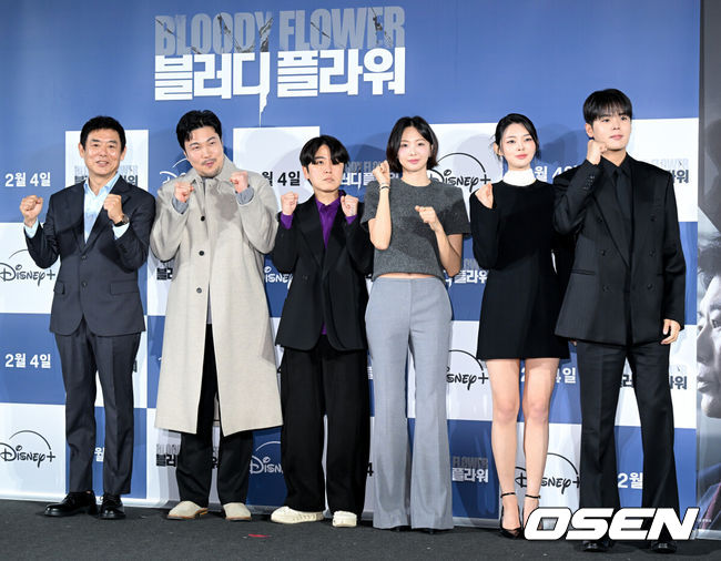 [OSEN=조은정 기자] 디즈니+ '블러디 플라워' 제작발표회가 27일 서울 용산구 CGV용산아이파크몰에서 열렸다.블러디 플라워‘는 모든 불치병을 치료할 수 있는 능력을 가진 연쇄살인범을 둘러싼 사람들의 이야기를 그린 미스터리 스릴러다.배우 성동일, 신승환, 한윤선 감독, 금새록, 정소리, 려운이 포즈를 취하고 있다. 2026.01.27 /cej@osen.co.kr