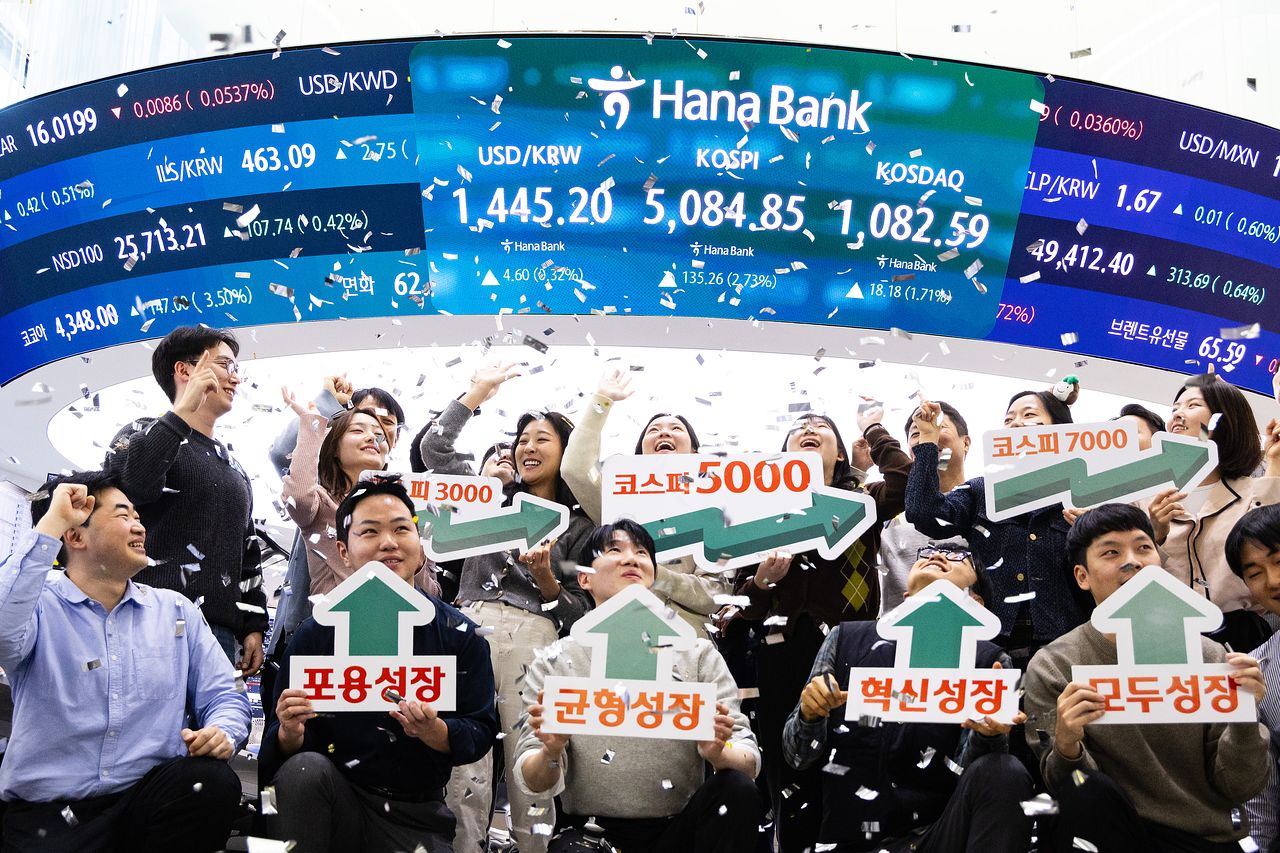 코스피 지수가 사상 처음으로 종가 5000을 넘은 27일 오후 서울 중구 하나은행 본점 딜링룸에서 직원들이 기념 행사를 하고 있다. 우상조 기자