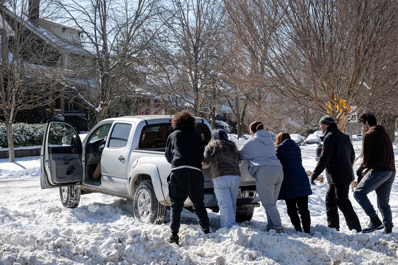 26일(현지시간) 미국 켄터키주 루이빌에서 눈더미에 묻힌 트럭을 사람들이 밀어 꺼내고 있다. AFP=연합뉴스