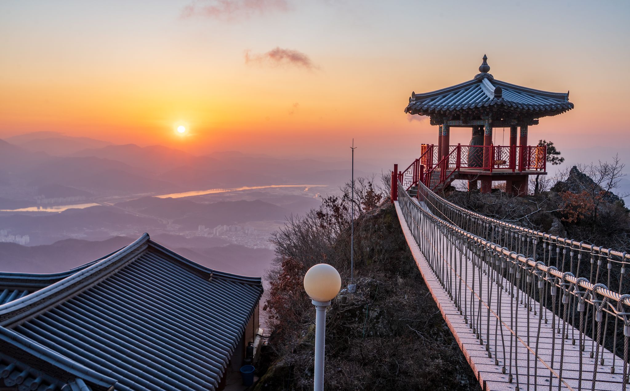 금오산 약사암 종각의 일출. 낙동강 너머로 겹겹이 포개진 산등성이 위에서, 해가 조심스레 고개를 들고 있다. 백종현 기자