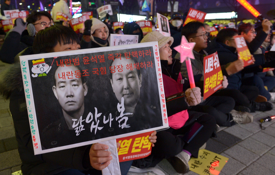 2024년 12월 11일 대전에서 열린 윤석열 대통령 탄핵 집회에서 한 참가자가 전두환 전 대통령과 윤 대통령의 합성 이미지를 함께 배치한 팻말을 들고 있다. 프리랜서 김성태