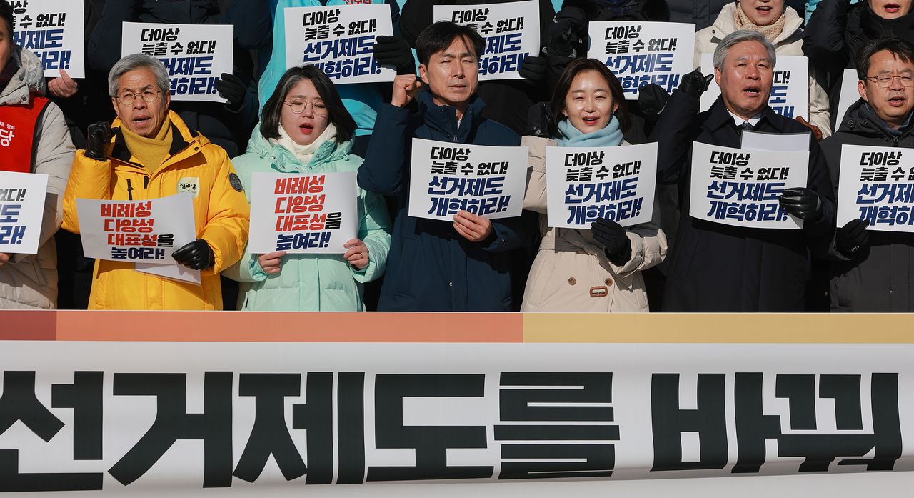 지난 21일 국회 본청 앞 계단에서 열린 선거제도·정치 개혁 촉구 기자회견에 참석한 조국혁신당 서왕진 원내대표(오른쪽 두번째부터), 진보당 김재연 상임대표, 사회민주당 한창민 대표 겸 원내대표, 기본소득당 용혜인 대표 겸 원내대표, 정의당 권영국 대표가 구호를 외치고 있다. 연합뉴스 