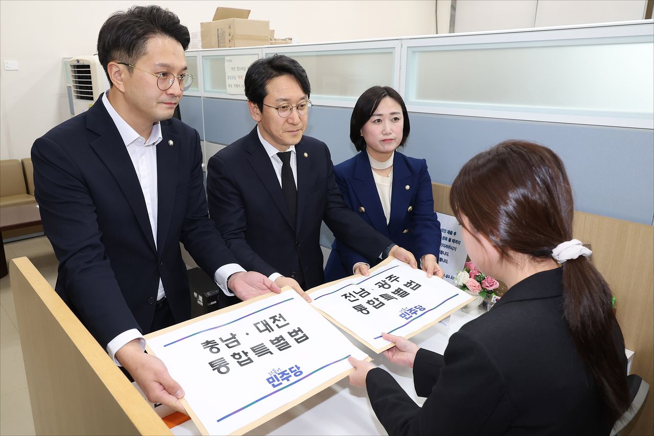 더불어민주당 천준호 원내수석부대표와 전용기 원내소통수석부대표, 백승아 원내대변인이 30일 서울 여의도 국회 의안과에 '충남·대전 통합특별법'과 '전남·광주 통합특별법'을 제출하고 있다. 뉴스1