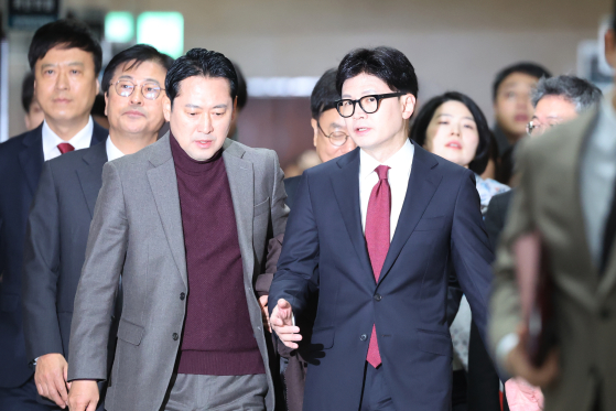 한동훈 전 국민의힘 대표(오른쪽)가 2024년 12일 서울 여의도 국회에서 열린 비공개 최고위원회의에 참석하며 장동혁 대표와 대화하고 있다. 연합뉴스