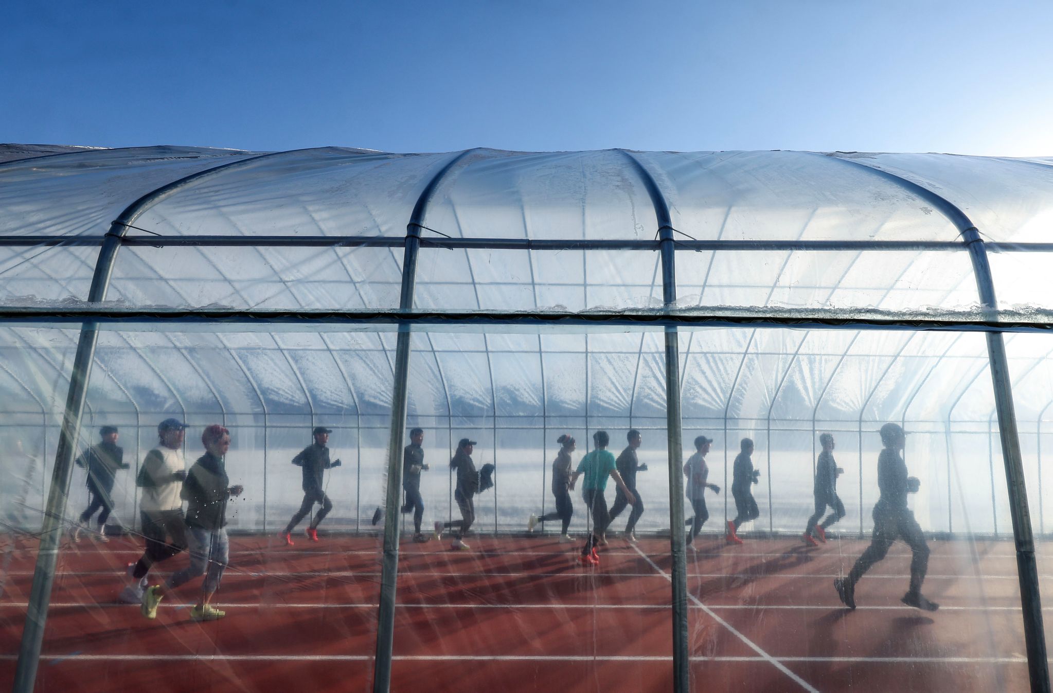 달리기 동호인들이 경기도 파주스타디움에 설치된 비닐하우스 트랙을 달리고 있다.