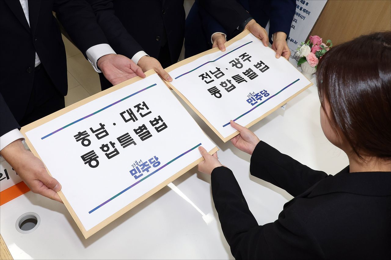 천준호 더불어민주당 원내수석부대표와 전용기 원내소통수석부대표, 백승아 원내대변인이 지난달 30일 서울 여의도 국회 의안과에 '충남·대전 통합특별법'과 '전남·광주 통합특별법'을 제출하고 있다. 뉴스1