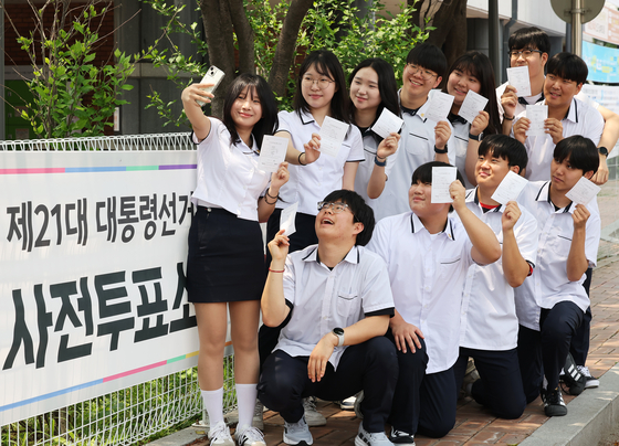 제21대 대통령선거 사전투표 첫날인 지난해 5월 29일 경기도 수원시 장안구 연무동행정복지센터에 마련된 투표소에서 투표를 마친 학생들이 인증 사진을 찍고 있다. 연합뉴스