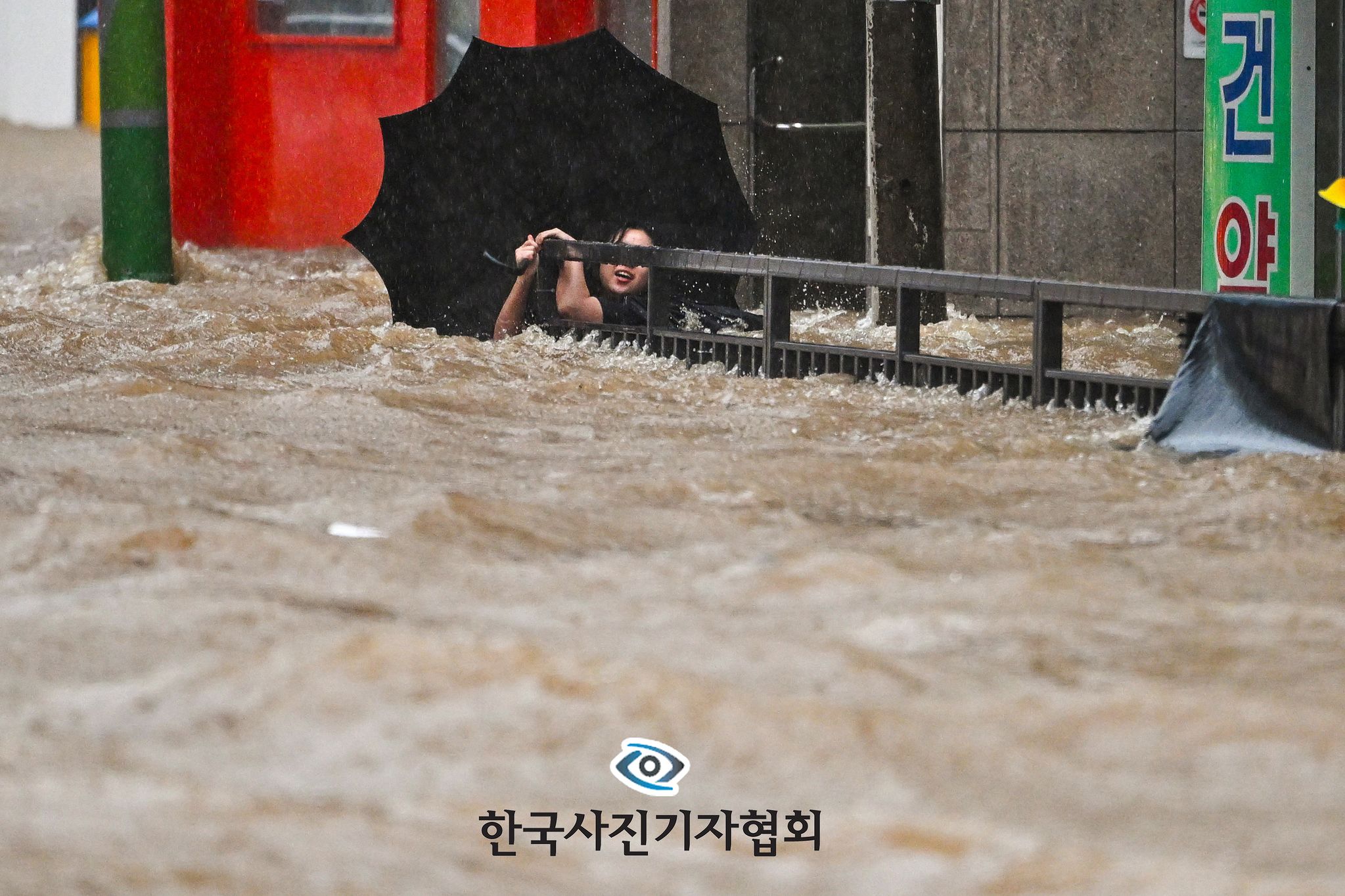 〈426mm 괴물 폭우 속 절체절명 시민 - 뉴스 우수상〉광주지역에 하루 동안 426.4㎜ 폭우가 쏟아진 2025년 7월 17일 오후 침수된 광주 북구청 앞 도로에서 한 시민이 물살에 휩쓸리던 중 난간을 겨우 붙잡아 목숨을 건지고 있다. 시민은 스스로 빠져나와 주변 건물로 안전하게 대피했다. 광주지역에 내린 이날 비의 양은 1939년 기상관측 이후 기록된 역대 최고 일강수량을 갈아치웠다. 이번 폭우로 광주에서 2명이 숨지고 이재민이 417명(287가구) 발생한 한편, 공공 및 민간 시설 피해 3838건이 집계돼 광주 북구 전지역?광주 광산구 어룡동과 삼도동이 특별재난지역으로 선포됐다. 뉴시스=이영주 기자