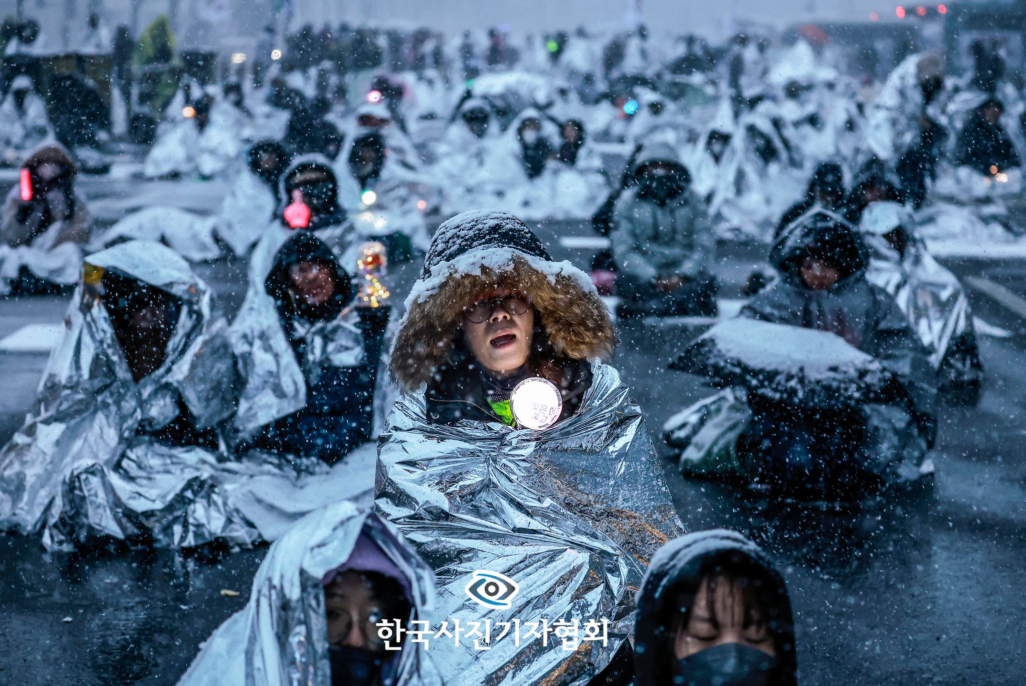〈'폭설 속 대통령 퇴진 외치는 키세스 시위대 - 대상〉2025년 1월 5일 서울 용산구 대통령 관저 인근에서 열린 1박 2일 민주노총 철야투쟁에서 시민들이 추위를 피하기 위해 보온용 은박 비닐을 덮은 채 자리를 지켰다. 이들의 모습이 미국 유명 초콜릿 브랜드 ‘키세스(Kisses)’를 연상시킨다는 이유로 ‘키세스 시위대’라는 별칭이 붙었다. 뉴시스=정병혁 기자