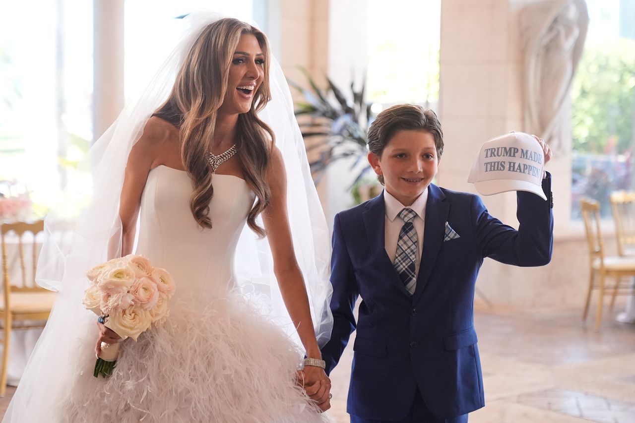 댄 스카비노 미국 백악관 부비서실장과 1일(현지시간) 플로리다주 팜비치의 마러라고 리조트에서 결혼식을 올린 에린 엘모어 국무부 공관예술 담당 국장(왼쪽). 엘모어의 옆에 있는 한 어린이는 ‘트럼프가 이것을 가능하게 했다’는 영어 문구가 적힌 야구 모자를 들어 보이고 있다. AP=연합뉴스